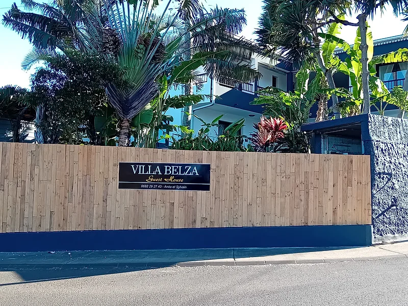 L'entrée de la Villa Belza, sa palissade en bois et la plaque bleu nuit